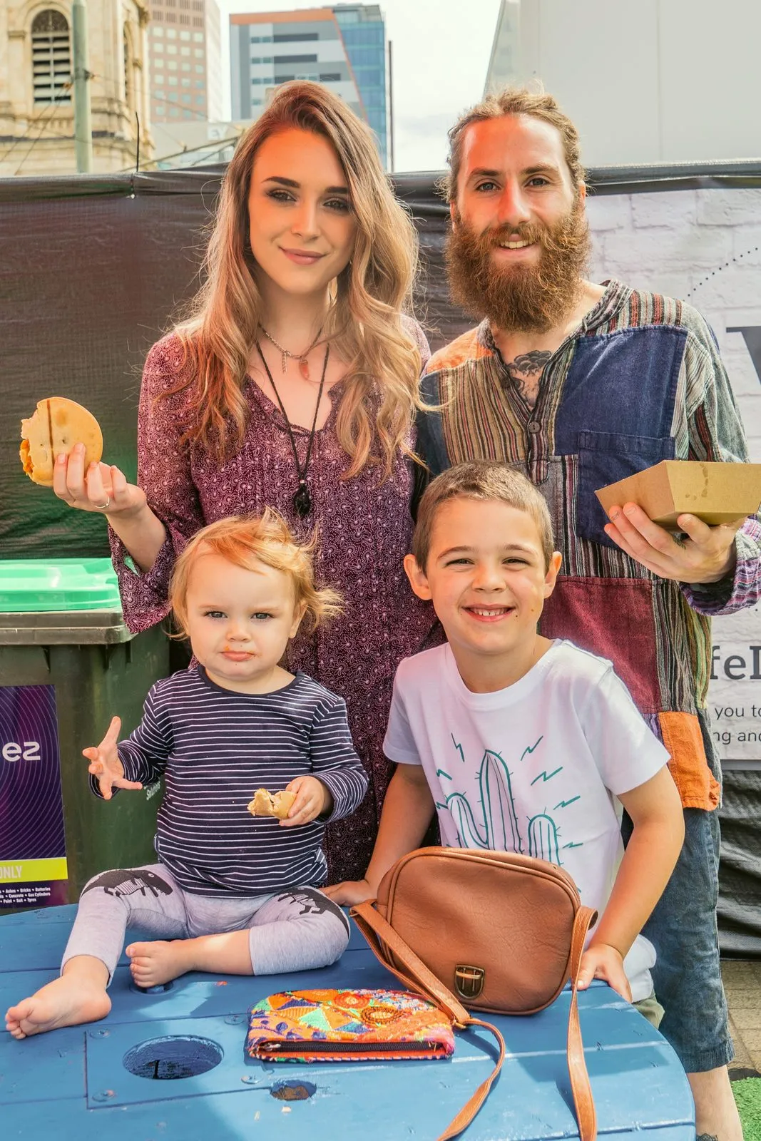 A young family with two children eating at a market stall at the Adelaide Vegan Festival