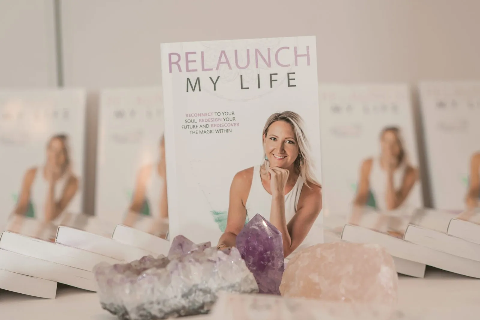 Copies of a book on the launch table beside amethyst and rose quartz crystals