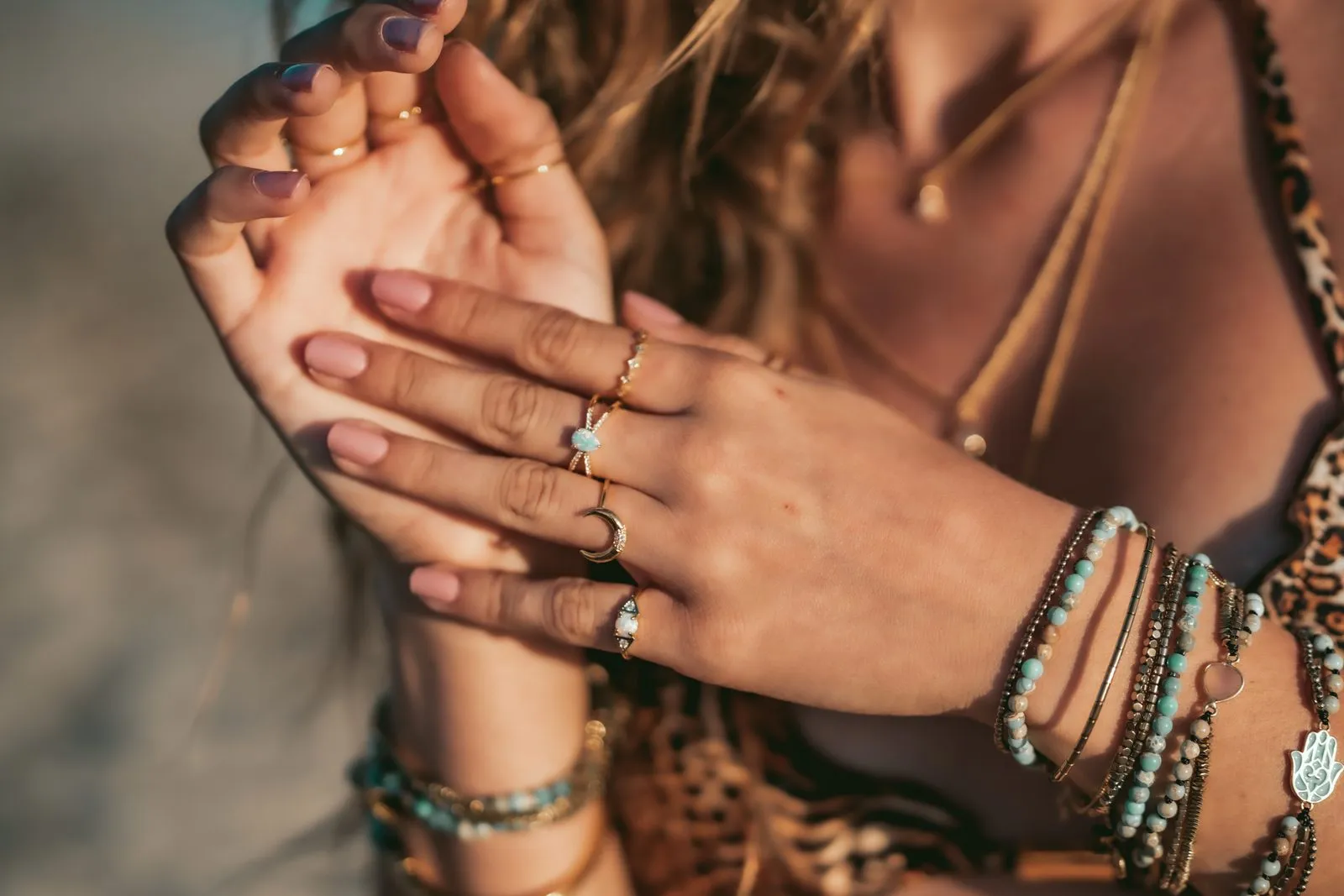 Hands stacked with gold rings and beaded bracelets, close up, Dreamers Ibiza jewellery