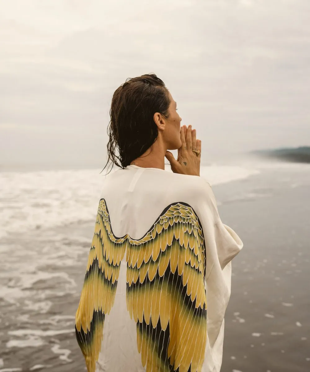 Fashion photography, three women in painted wing kimonos walking into the surf