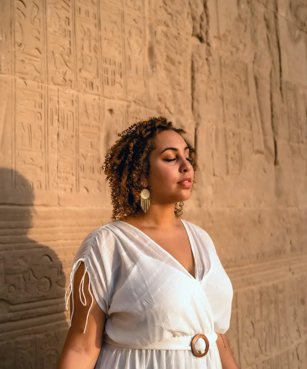 Goddess photography, a woman in prayer at the water at sunset