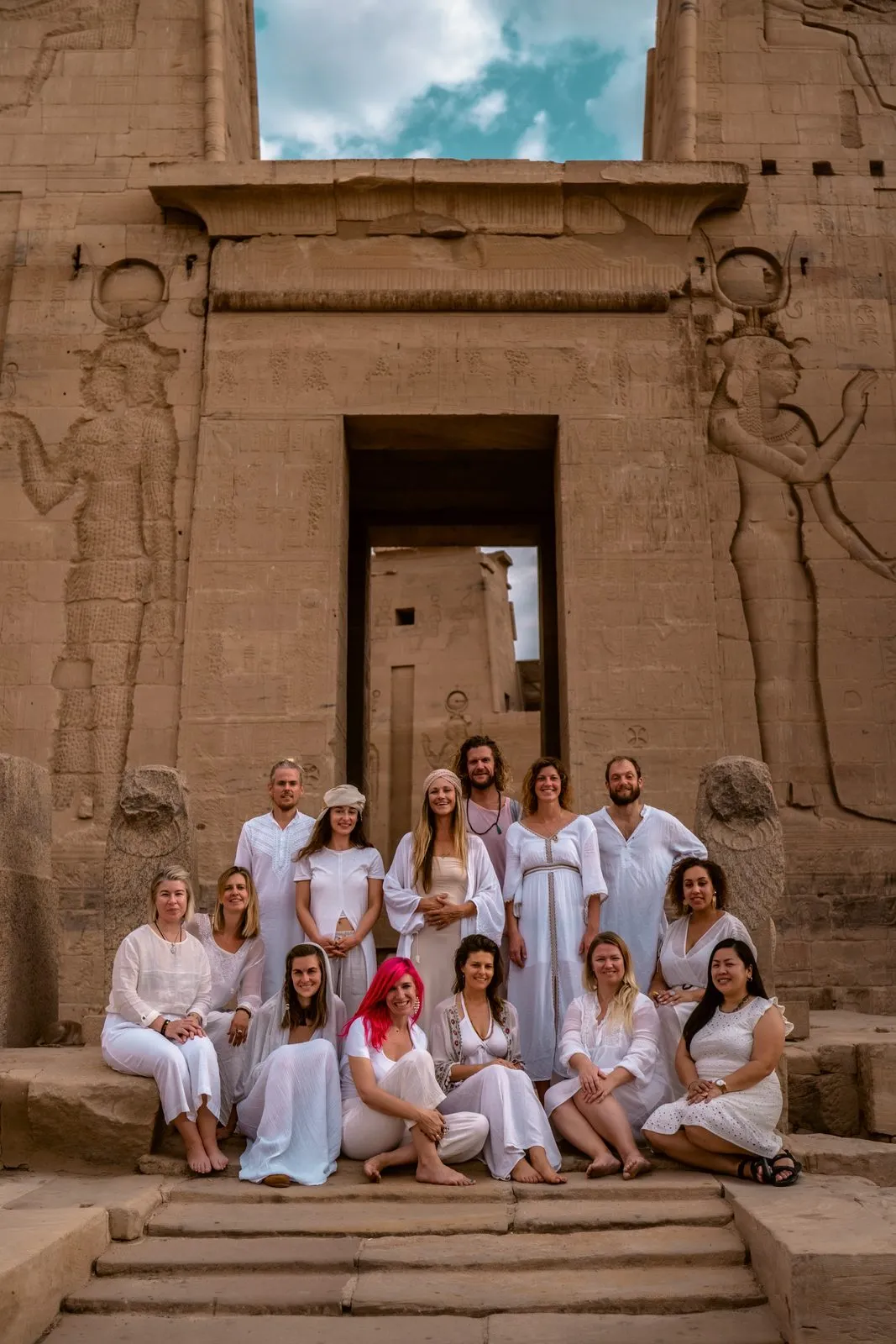 A retreat group in white gathered on the steps before a temple gateway at Philae, Egypt